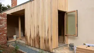 Sustainable house materials on partially built eco home with timber cladding and lime render.