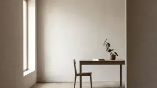 Architecture student desk with white study model and monitor showing a realistic interior render workflow.
