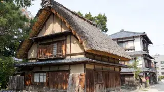 Traditional Japanese house types shown side by side, including a steep thatched rural house and an urban townhouse.