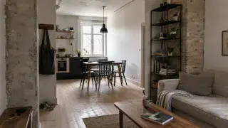 Scandinavian industrial apartment with brick, black metal shelving, pale wood, sofa, shoes, and daylight.