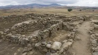 Early stone settlement walls in a dry archaeological landscape.
