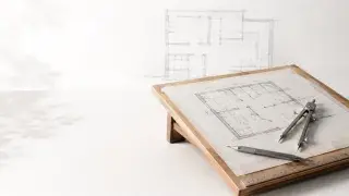 Drafting board with floor plan, compass, pencil, scale, and soft architectural sketch.