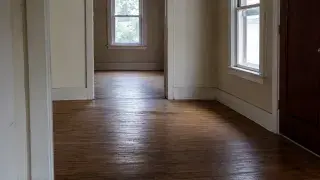 Old house hallway with a broad sagging hardwood floor.