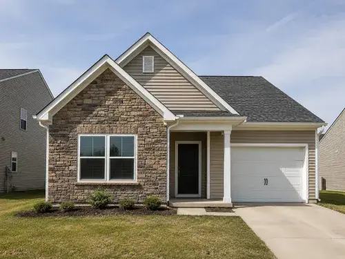 Suburban house with two front gables, stone veneer, siding, and attached garage.