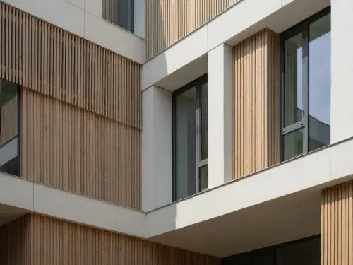 Modern facade with vertical timber screens, deep window reveals, and light mineral cladding panels.
