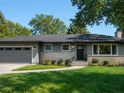 Updated 1960s ranch house exterior with low roofline, attached garage, cleaner entry, balanced windows, repaired trim, and restrained landscaping.
