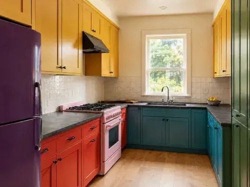 Color-blocked kitchen with red, teal, yellow and green cabinets.