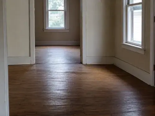 Old house hallway with a broad sagging hardwood floor.