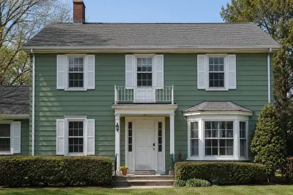 Renovated 1950s Colonial Revival home with fresh green exterior.