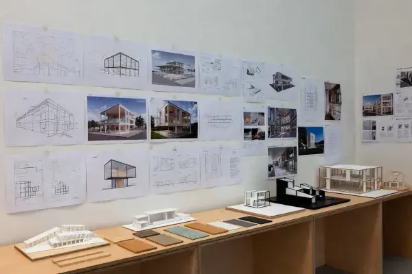 Architecture studio wall with sustainable design course boards, models, and material samples.