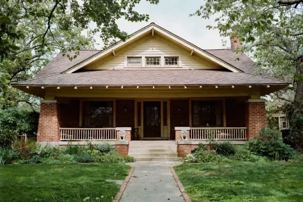 Early twentieth-century Craftsman house with broad eaves, grouped windows, and a deep front porch.