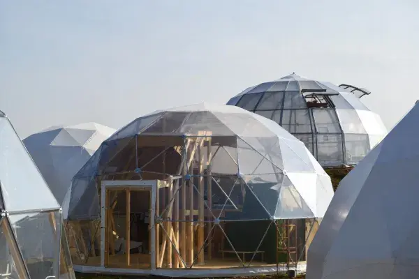 Cluster of geodesic dome structures with visible faceted framing and translucent exterior panels.