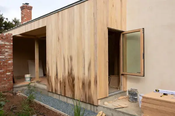 Sustainable house materials on partially built eco home with timber cladding and lime render.