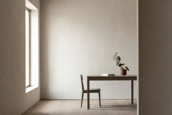 Architecture student desk with white study model and monitor showing a realistic interior render workflow.