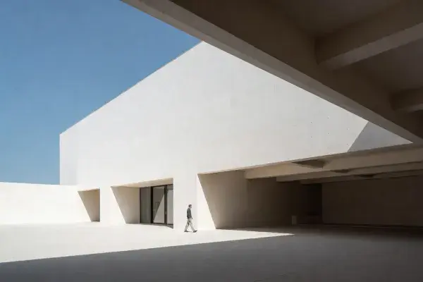 Architectural space with a small human figure under a deep overhang showing scale and proportion.