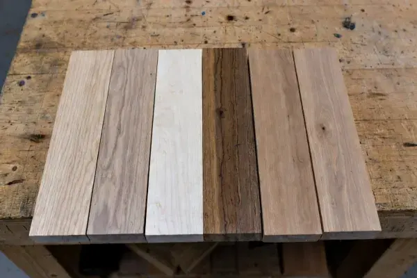Six unfinished hardwood samples on a worn cabinetmaker’s bench.